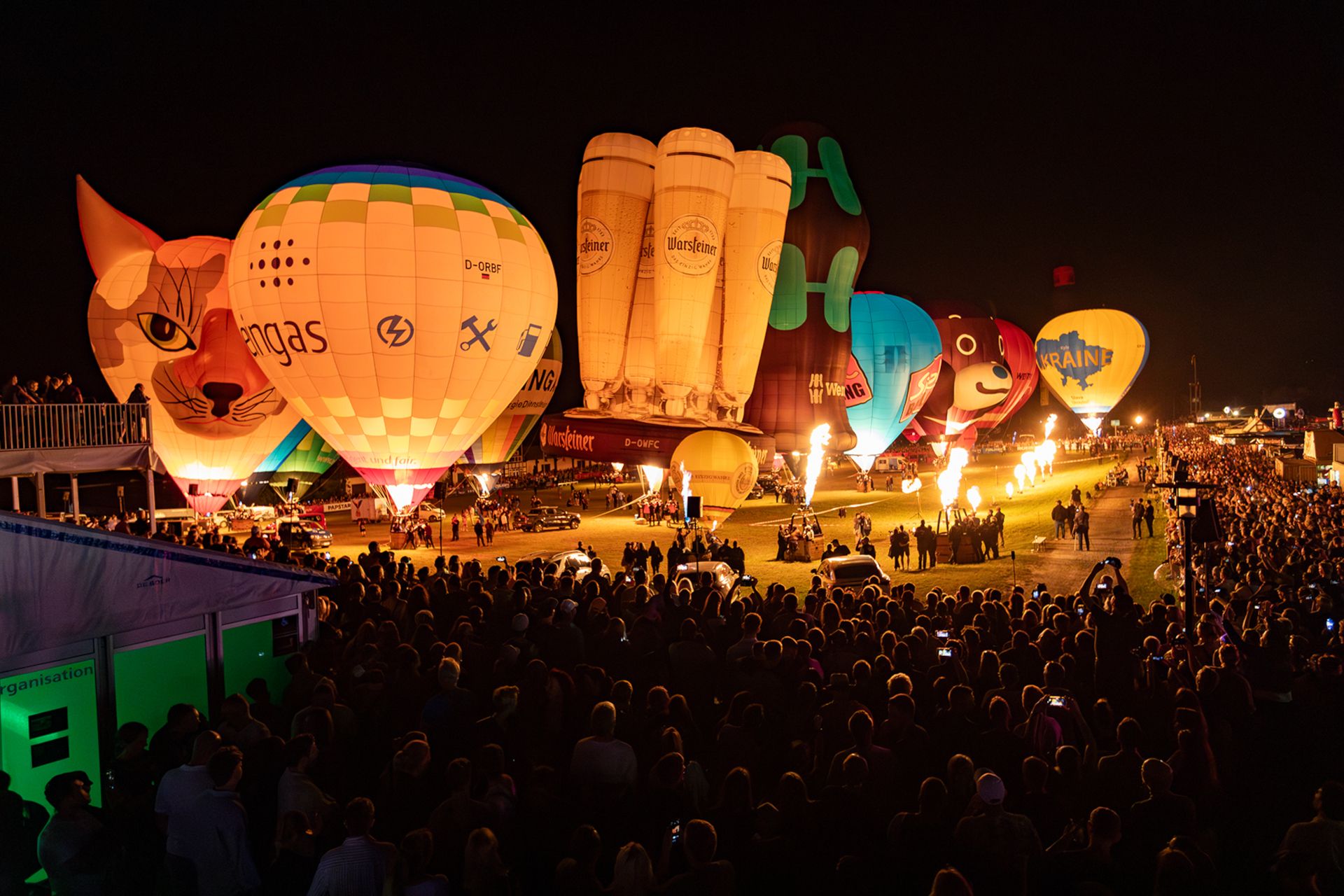 Bij Night-Glow verlichten vlammen de prachtige luchtballonnen in het donker