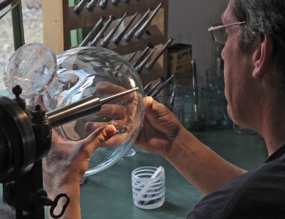 Glasblazers graveren af en toe hun werk in de glasblazerij van Gernheim