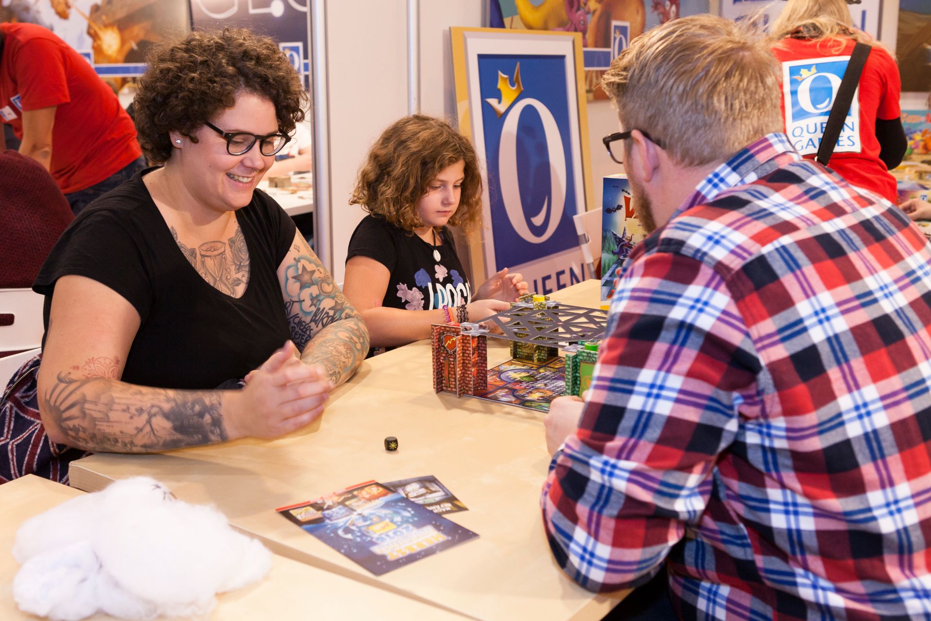 Jong en oud leren hoe individuele spellen werken op de beursstands van SPIEL Essen