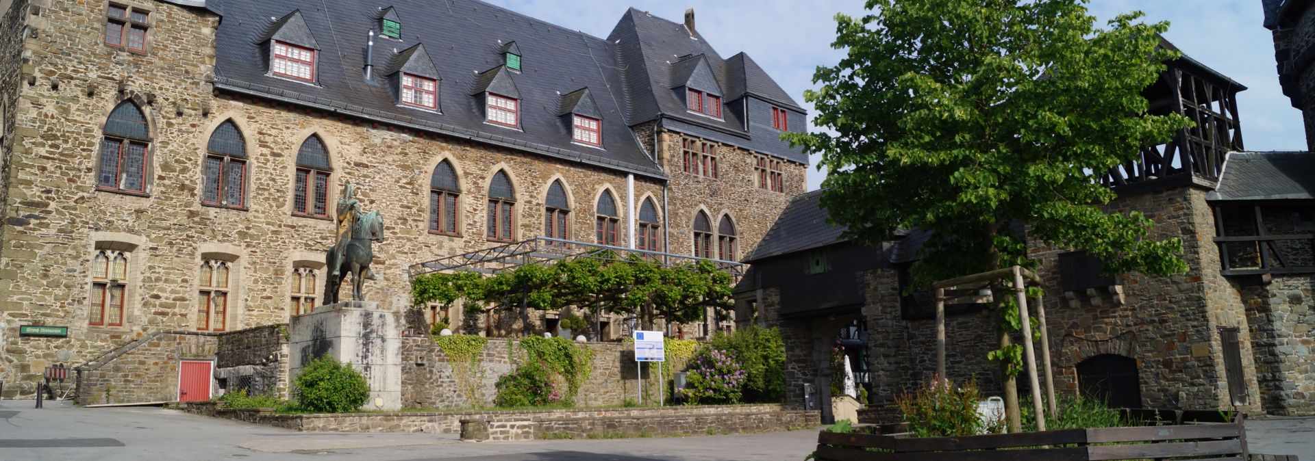 Het ruiterstandbeeld van graaf Engelbert II van Berg en aartsbisschop van Keulen verwelkomt gasten op het voorplein van het kasteel