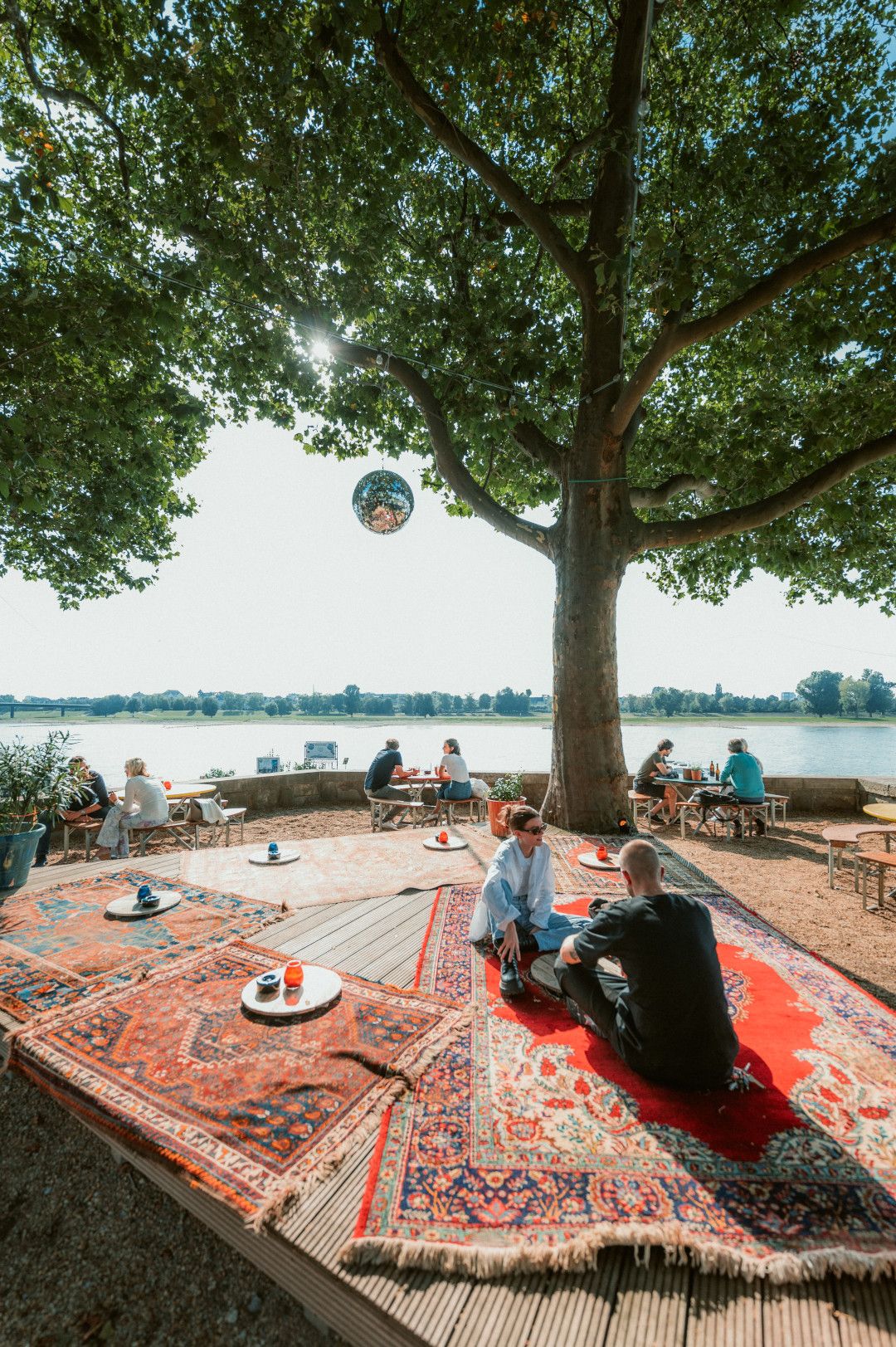 Zitten aan het water onder een boom bij Three Little Birds 