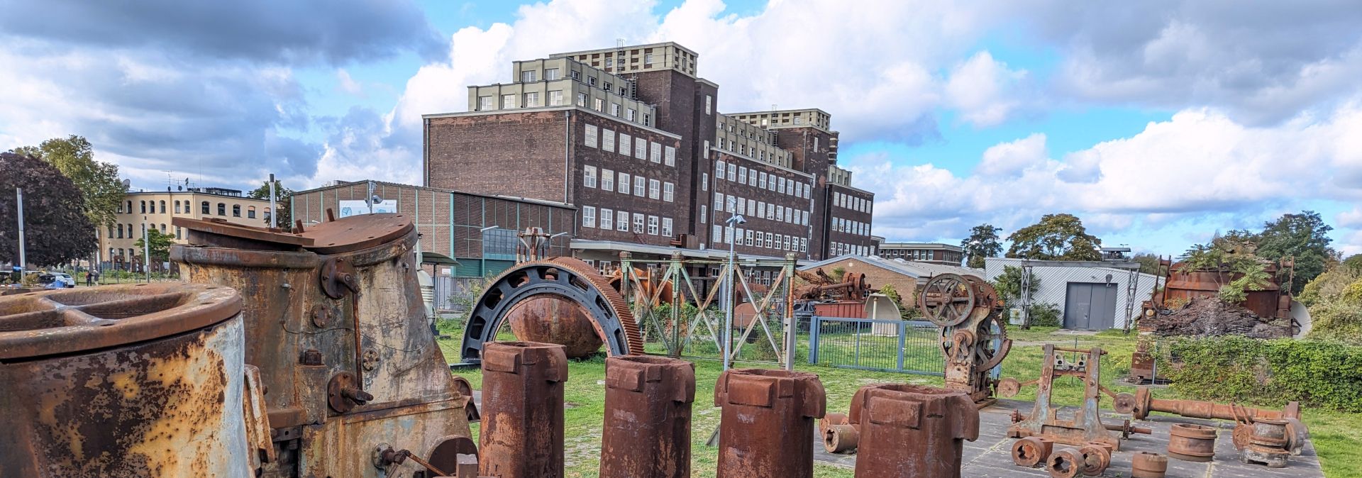 Op het terrein van het Peter Behrens-gebouw geven historische machines individuele werkprocessen in de zware industrie weer.