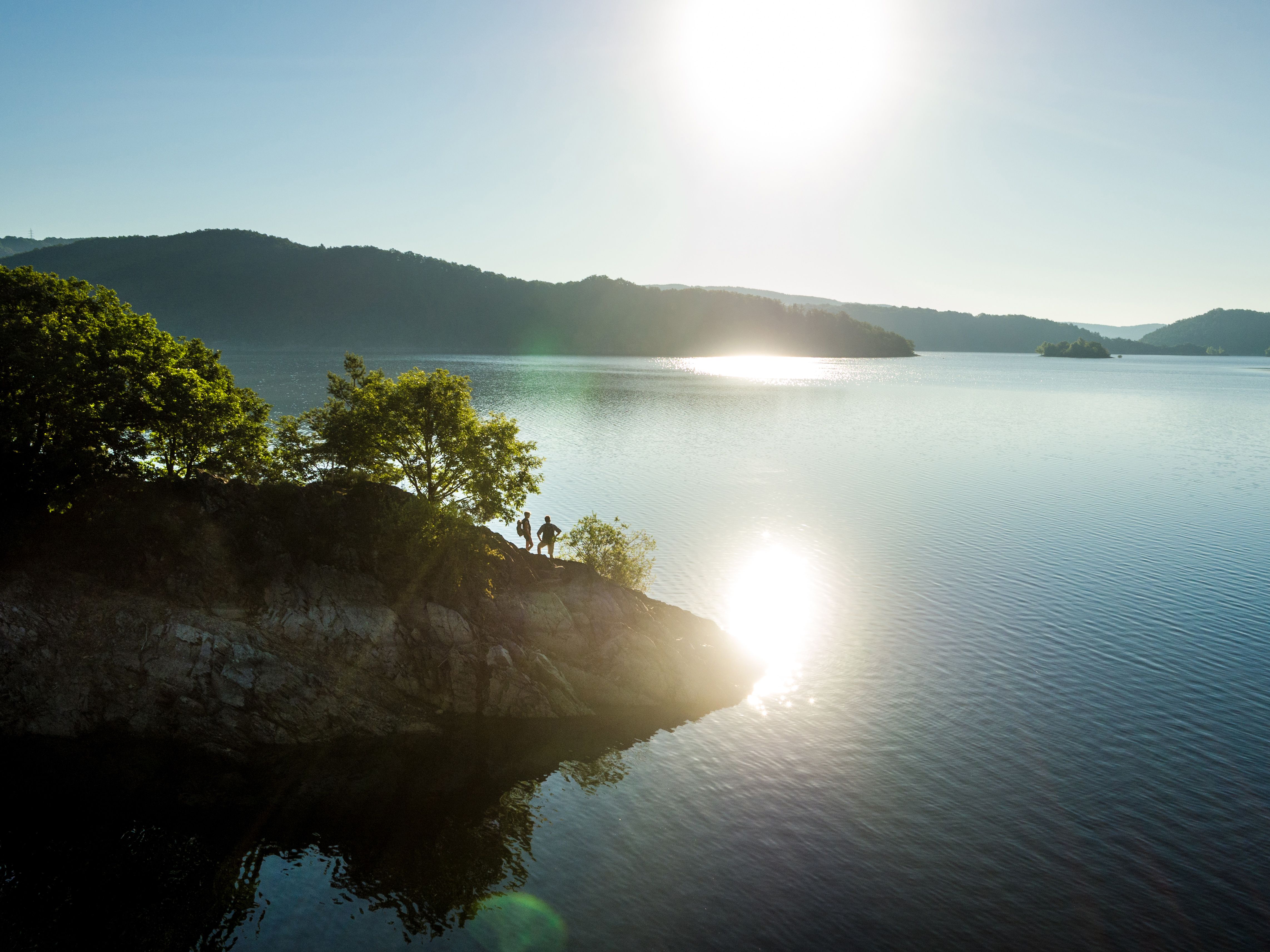 Der Rursee mit spiegelnder Sonne in der Eifel