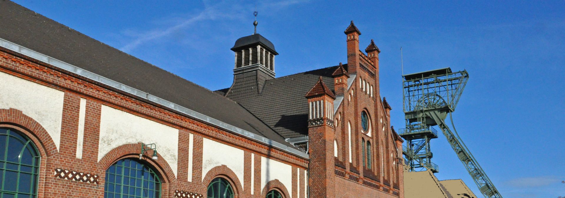 Een bakstenen gevel, een Art Nouveau portaal en twee kronkelende torens kenmerken de kolenmijn Zollern in Dortmund